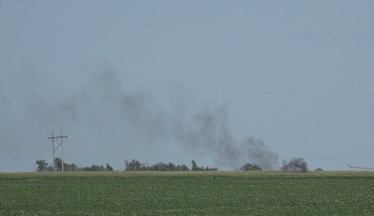 Black smoke rolls out of a cornfield 1.5 miles northeast of Deshler on Wednesday after a crop duster went down shortly before 2 p.m. The pilot, Nick Bagley, walked away with no major injury.