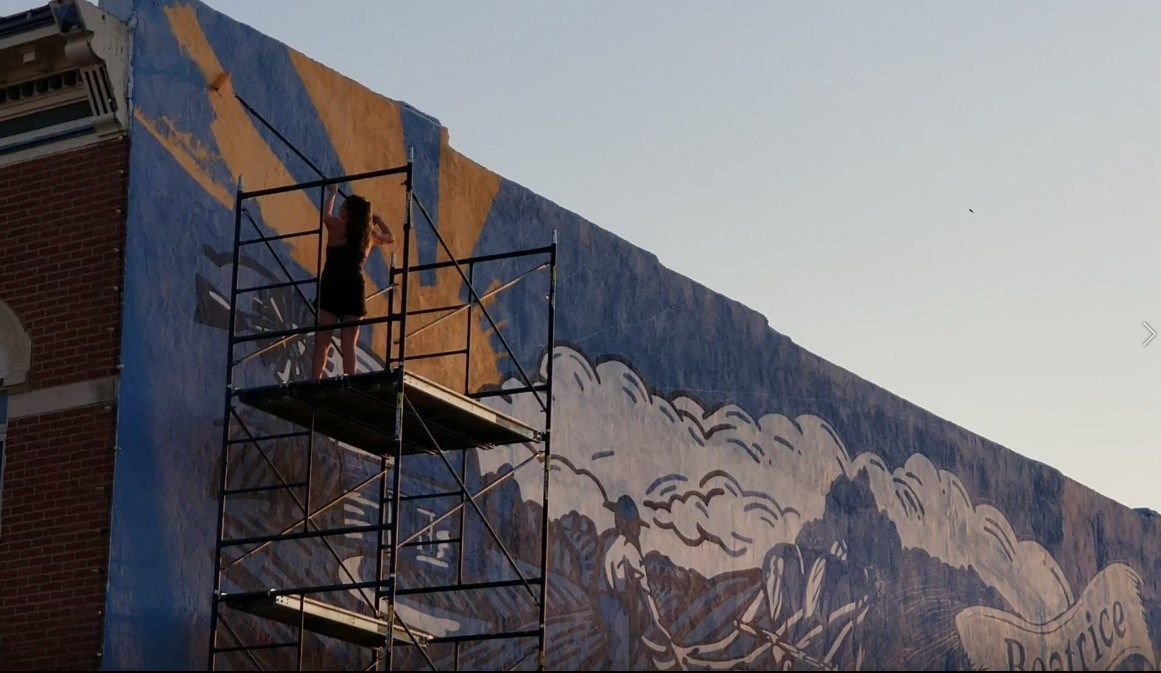 Graphic Designer Sydney Saathoff painting mural