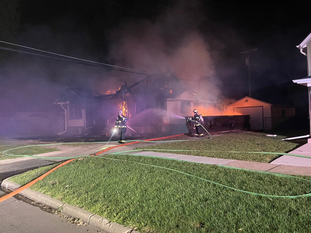Firefighters fighting a structures fire with visible damage to the structure. Firefighters fighting a structures fire with visible damage to the structure.