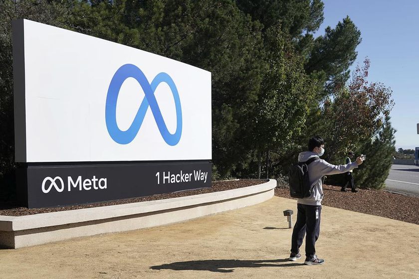 A Facebook employee take a selfie in front the company's new name and logo outside its headquarters in Menlo Park, Calif., Thursday, Oct. 28, 2021, after announcing that it is changing its name to Meta Platforms Inc.