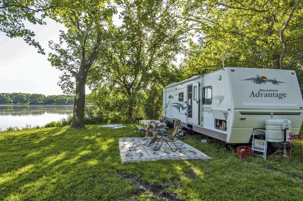 A camper sits in front of his RV at a lakeside campground at Alexandria Lakes State Recreation Area in Jefferson County.